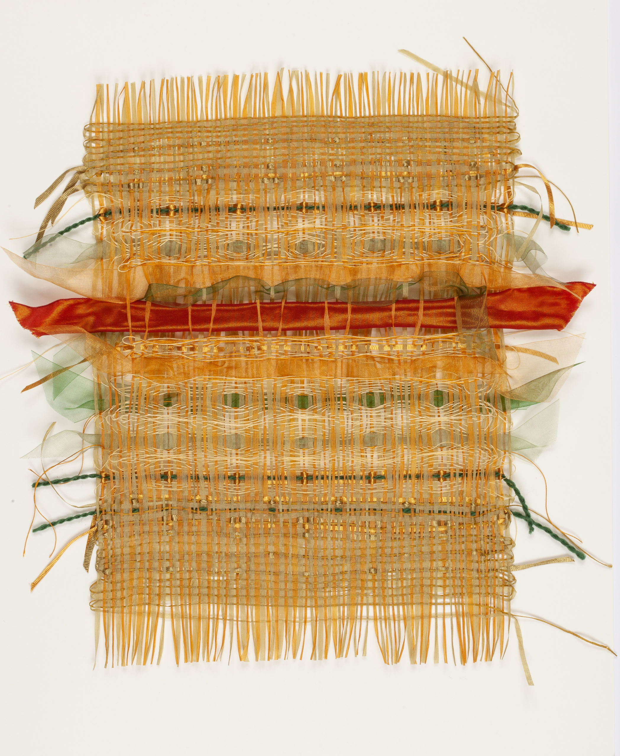 A hand woven weavescape in golds, red and green