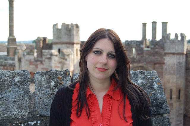 Historian Dr Janina Ramirez standing in front of Berkeley Castle